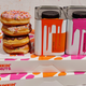 Cans of paint and doughnuts stacked on top of Dunkin' boxes